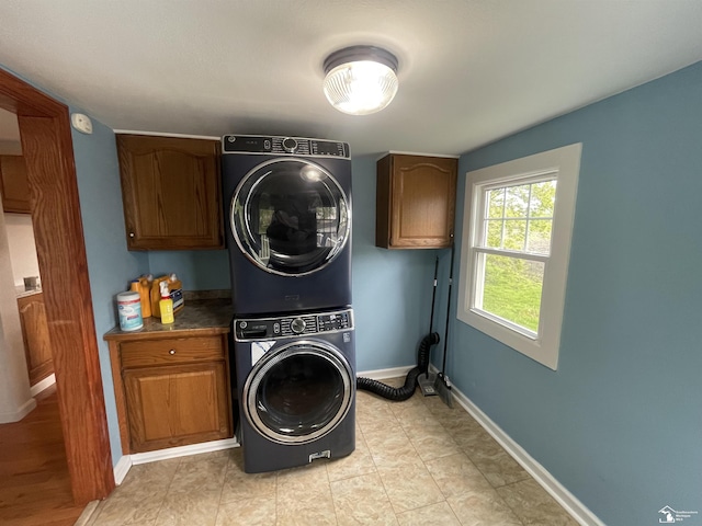 6301 E Albain Rd, Monroe, MI 48161 - laundry area with stacked washer and clothes dryer, cabinet space, and baseboards