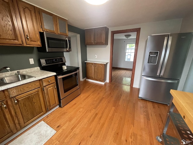 6301 E Albain Rd, Monroe, MI 48161 - kitchen featuring stainless steel appliances, a sink, light wood-style floors, light countertops, and brown cabinetry
