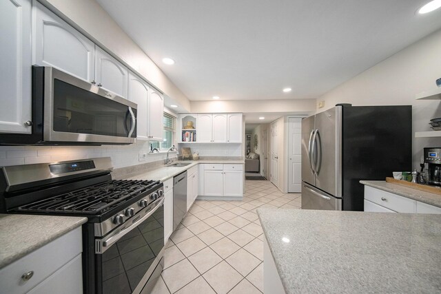 489 Old Creek Ct, Saline, MI 48176 - kitchen featuring appliances with stainless steel finishes, a sink, white cabinets, backsplash, and open shelves