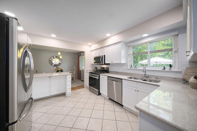 489 Old Creek Ct, Saline, MI 48176 - kitchen featuring stainless steel appliances, a sink, white cabinetry, light tile patterned flooring, and recessed lighting