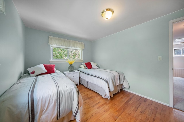 489 Old Creek Ct, Saline, MI 48176 - bedroom featuring multiple windows, light wood-type flooring, and baseboards