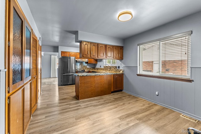 18607 Colonial Ct, Allen Park, MI 48101 - kitchen featuring freestanding refrigerator, brown cabinets, a peninsula, light wood-type flooring, and stainless steel range with electric stovetop