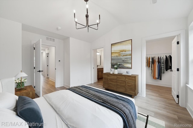 1685 Pinecroft Ln, Howell, MI 48855 - bedroom featuring a chandelier, light wood-style floors, a spacious closet, a closet, and lofted ceiling
