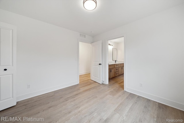 1685 Pinecroft Ln, Howell, MI 48855 - unfurnished bedroom with light wood finished floors, baseboards, and connected bathroom