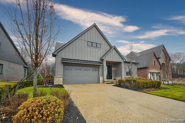 4174 Prescott Park Cir W, Bloomfield, MI 48323 - view of front facade featuring board and batten siding, concrete driveway, a standing seam roof, metal roof, and stone siding