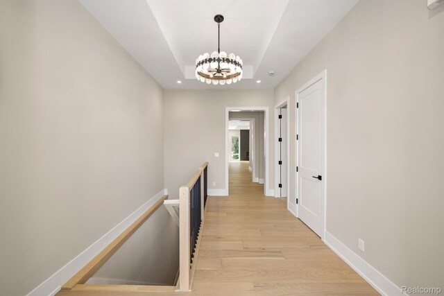 4174 Prescott Park Cir W, Bloomfield, MI 48323 - hallway with an upstairs landing, light wood finished floors, baseboards, a tray ceiling, and a chandelier