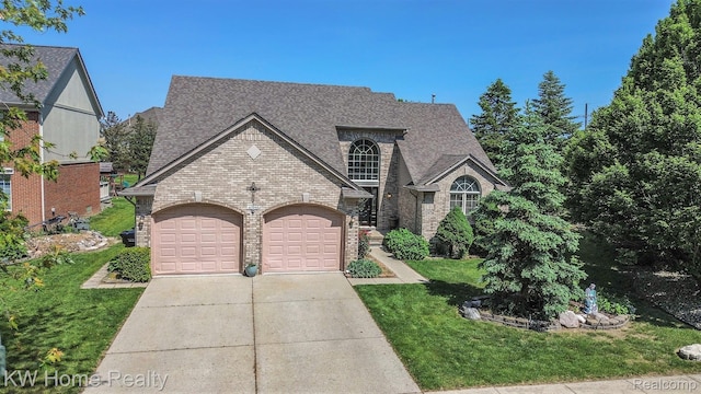 47040 W Wayford Dr, Shelby Twp, MI 48315 - french provincial home featuring brick siding, a front yard, a shingled roof, an attached garage, and concrete driveway
