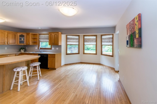 10399 Allen Rd, Clarkston, MI 48348 - kitchen with black dishwasher, light countertops, a breakfast bar area, a sink, and baseboards