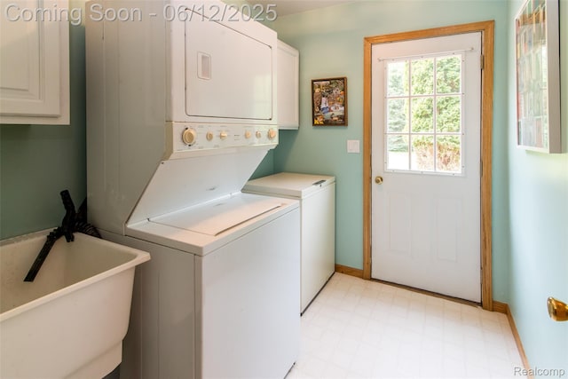 10399 Allen Rd, Clarkston, MI 48348 - laundry room with cabinet space, stacked washing machine and dryer, light flooring, and baseboards