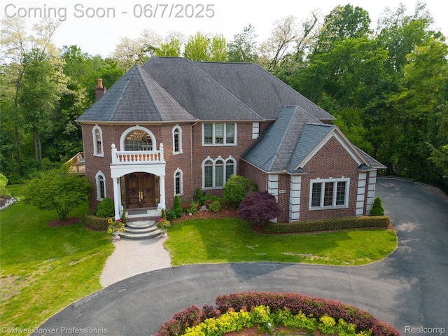 4546 Forest Edge Ln, West Bloomfield, MI 48323 - colonial home featuring brick siding, a front yard, a chimney, a balcony, and asphalt driveway