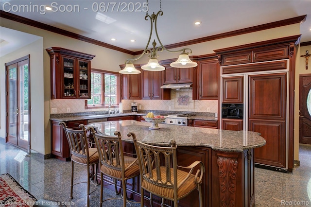 4546 Forest Edge Ln, West Bloomfield, MI 48323 - kitchen with granite tiled floors, under cabinet range hood, a kitchen island, recessed lighting, and glass insert cabinets
