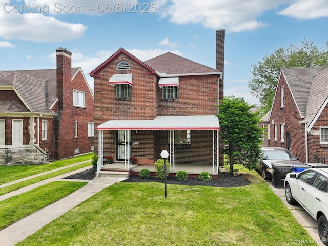 17321 Snowden St, Detroit, MI 48235 - view of front of property with brick siding, a front yard, a chimney, and a porch
