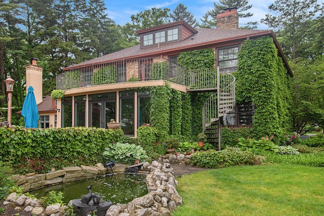 371 Waukazoo Dr, Holland, MI 49424 - rear view of house with stairs, a chimney, a garden pond, a yard, and a shingled roof