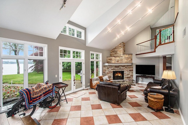371 Waukazoo Dr, Holland, MI 49424 - living room featuring high vaulted ceiling, track lighting, a fireplace, light tile patterned floors, and french doors
