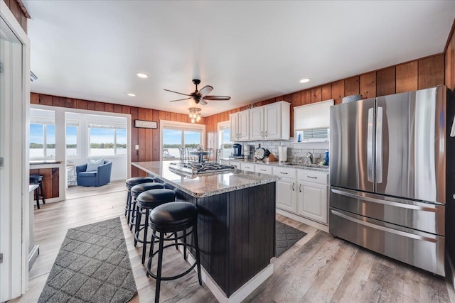 4805 Pinellas Dr, Hale, MI 48739 - kitchen featuring stainless steel appliances, a breakfast bar area, light stone counters, a sink, and a center island