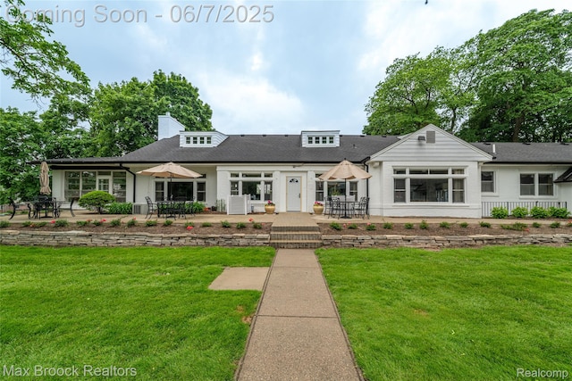 42160 Woodward Ave Unit 37, Bloomfield Hills, MI 48304 - view of front facade with a patio area, a front yard, a shingled roof, and outdoor dining space