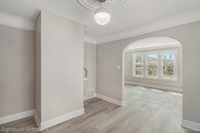 16762 Woodingham Dr, Detroit, MI 48221 - unfurnished room featuring arched walkways, a textured ceiling, wood finished floors, a chandelier, and baseboards