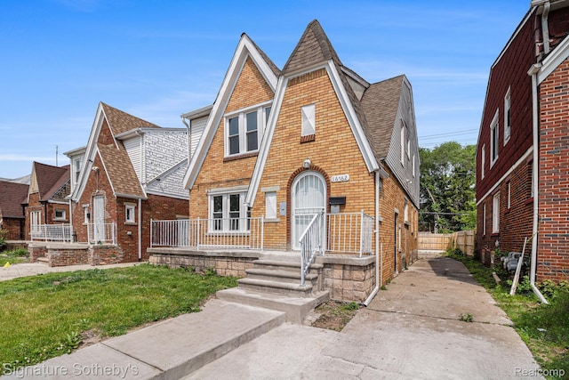 16762 Woodingham Dr, Detroit, MI 48221 - tudor home featuring roof with shingles, brick siding, and concrete driveway