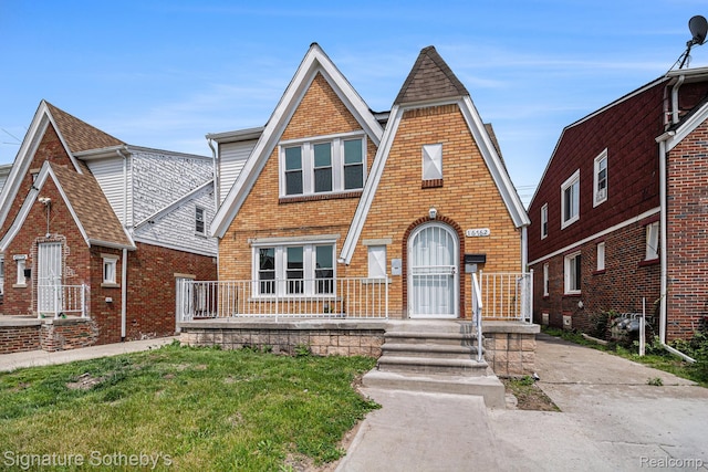16762 Woodingham Dr, Detroit, MI 48221 - tudor house with brick siding, a shingled roof, and a front lawn