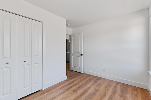 2023 Green Acres Dr, Adrian, MI 49221 - unfurnished bedroom with baseboards, a closet, and light wood-style floors