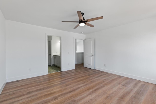 2023 Green Acres Dr, Adrian, MI 49221 - unfurnished bedroom featuring light wood-style floors, baseboards, connected bathroom, and ceiling fan