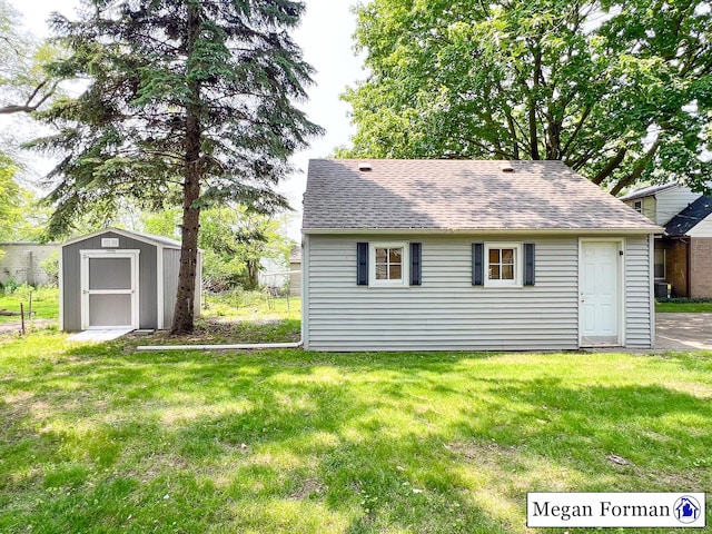 426 Mae-Thy St SE, Grand Rapids, MI 49548 - rear view of house featuring a shingled roof and a lawn