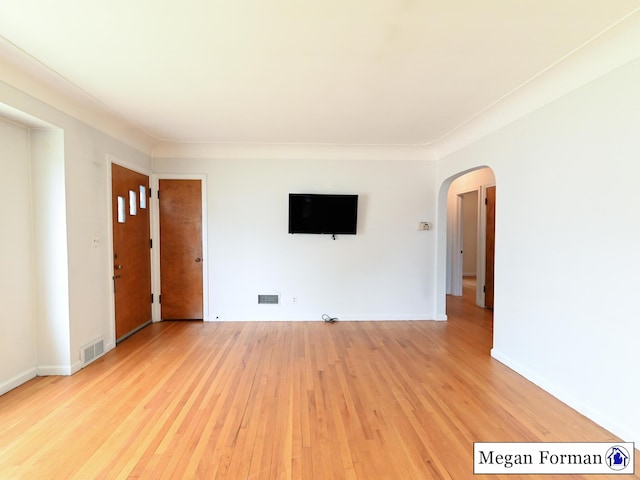 426 Mae-Thy St SE, Grand Rapids, MI 49548 - unfurnished living room with arched walkways, light wood-style flooring, and baseboards