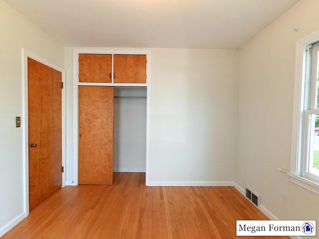 426 Mae-Thy St SE, Grand Rapids, MI 49548 - unfurnished bedroom featuring light wood-style flooring, a closet, and baseboards