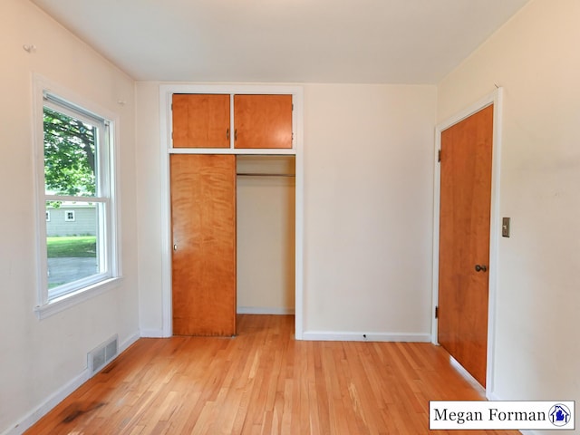 426 Mae-Thy St SE, Grand Rapids, MI 49548 - unfurnished bedroom with light wood-type flooring, a closet, and baseboards