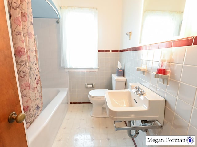 426 Mae-Thy St SE, Grand Rapids, MI 49548 - full bath featuring tile walls, toilet, wainscoting, and shower / tub combo