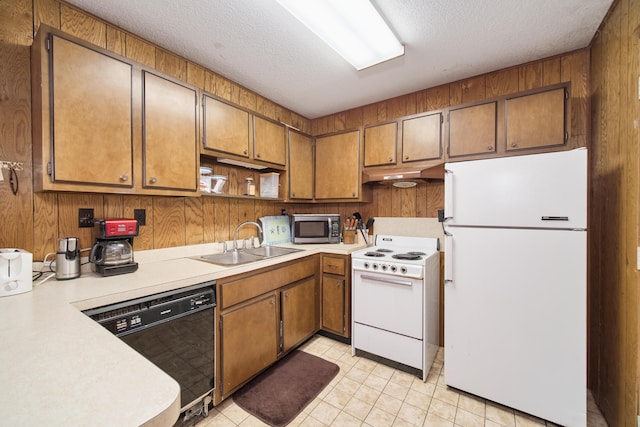 6387 N Larson Rd, Fountain, MI 49410 - kitchen featuring white appliances, a sink, under cabinet range hood, brown cabinetry, and a textured ceiling