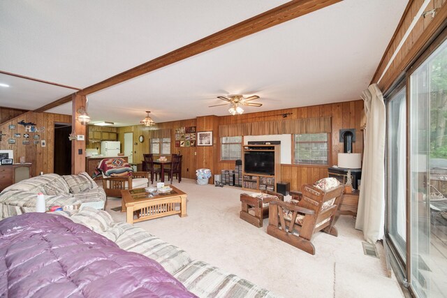 6387 N Larson Rd, Fountain, MI 49410 - carpeted living room with wooden walls, ceiling fan, and a wood stove