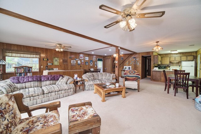 6387 N Larson Rd, Fountain, MI 49410 - living area with wooden walls, ceiling fan, light carpet, and beamed ceiling
