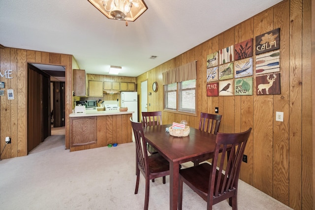 6387 N Larson Rd, Fountain, MI 49410 - dining area featuring wood walls and light carpet