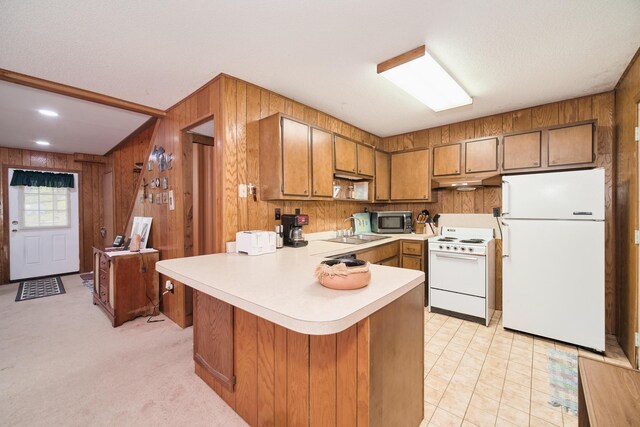 6387 N Larson Rd, Fountain, MI 49410 - kitchen featuring white appliances, light countertops, brown cabinetry, wooden walls, and under cabinet range hood