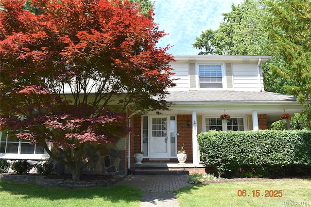 6560 Perham Dr, West Bloomfield, MI 48322 - view of front of house with a porch, brick siding, a shingled roof, and a front lawn