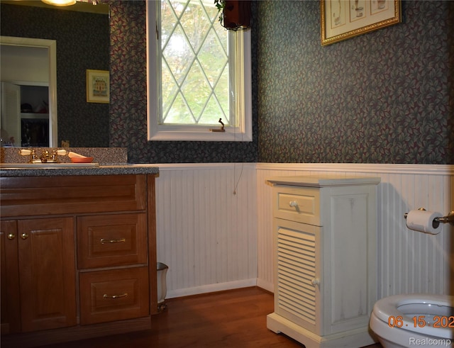 6560 Perham Dr, West Bloomfield, MI 48322 - bathroom with a wainscoted wall, wood finished floors, vanity, and wallpapered walls