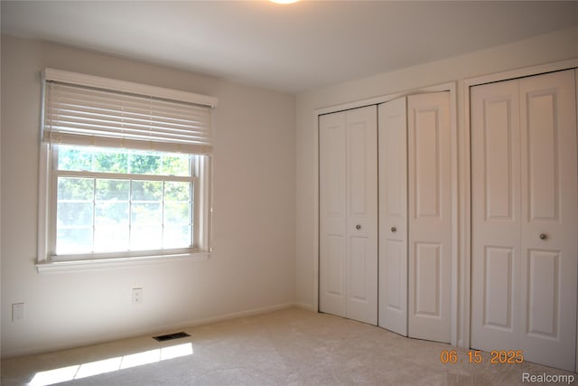 6560 Perham Dr, West Bloomfield, MI 48322 - unfurnished bedroom with carpet flooring and two closets