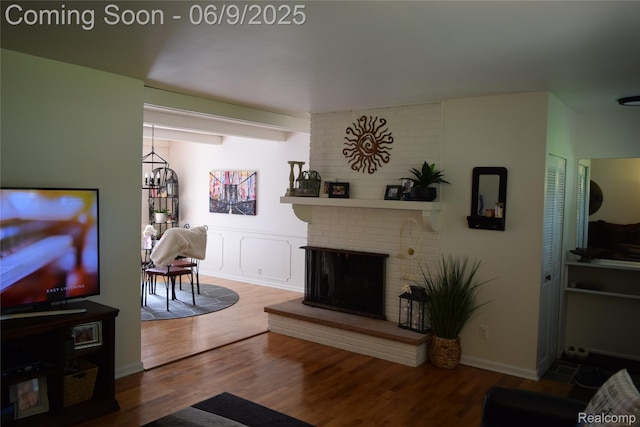 6009 Lancaster Dr, Flint, MI 48532 - living area with wood finished floors, a fireplace, and a chandelier