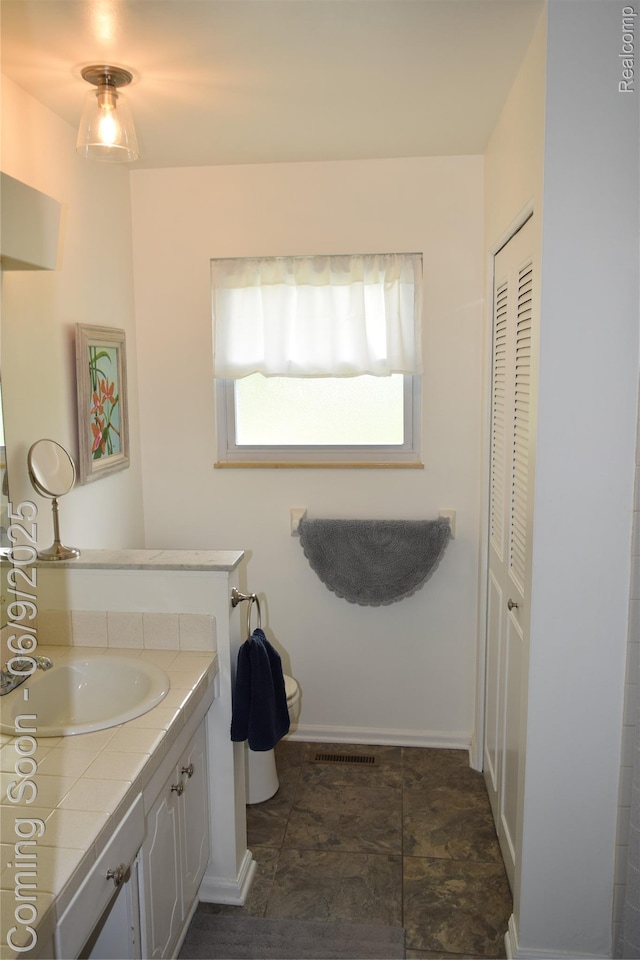 6009 Lancaster Dr, Flint, MI 48532 - bathroom featuring vanity, toilet, and a closet