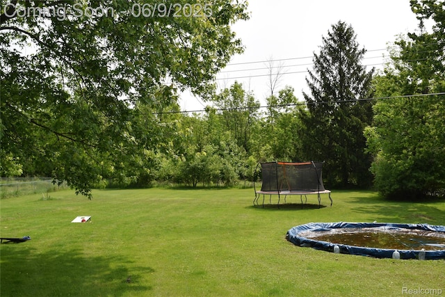 6009 Lancaster Dr, Flint, MI 48532 - view of green lawn with a trampoline