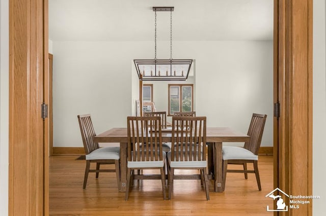 448 Borgess Ave, Monroe, MI 48162 - dining space with light wood finished floors, a chandelier, and baseboards