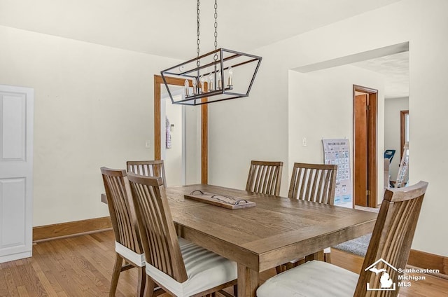 448 Borgess Ave, Monroe, MI 48162 - dining area featuring a chandelier, light wood-style floors, and baseboards
