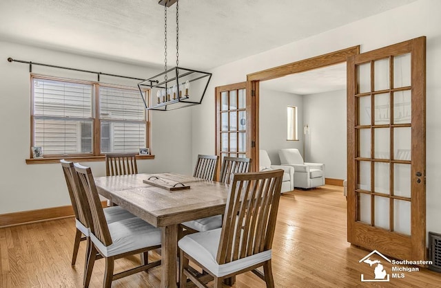 448 Borgess Ave, Monroe, MI 48162 - dining area with baseboards, a chandelier, and light wood-type flooring