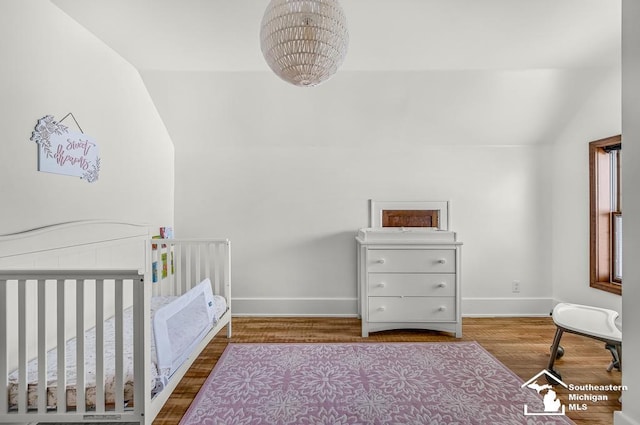 448 Borgess Ave, Monroe, MI 48162 - bedroom featuring lofted ceiling, baseboards, wood finished floors, and a crib