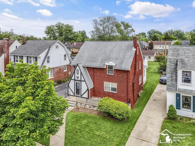 448 Borgess Ave, Monroe, MI 48162 - view of side of property with a residential view, brick siding, a chimney, driveway, and a yard