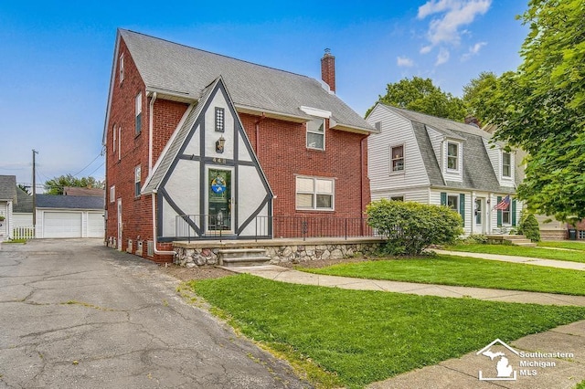 448 Borgess Ave, Monroe, MI 48162 - view of front of home featuring a garage, brick siding, a chimney, an outbuilding, and a front lawn