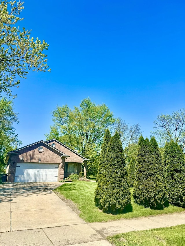15338 Flanders St, Southgate, MI 48195 - view of front facade featuring driveway, a front lawn, and a garage