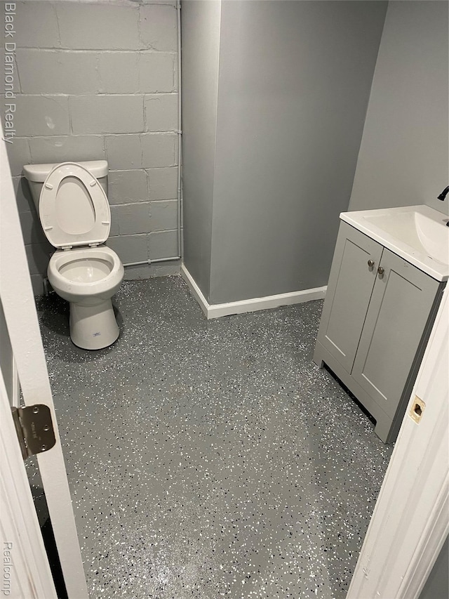 18499 Gruebner St, Detroit, MI 48234 - bathroom featuring vanity, toilet, concrete block wall, and baseboards
