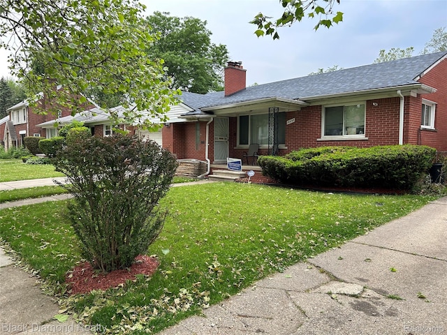 18499 Gruebner St, Detroit, MI 48234 - view of front of house featuring brick siding, a chimney, a front yard, and covered porch